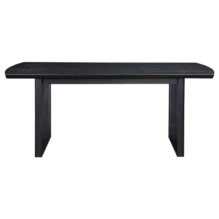 Brookmead 100-inch extension leaf dining table in black by CoasterEssence, showcasing a sleek, sturdy furniture piece with a polished surface.