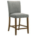 Set of two grey upholstered CoasterEveryday Paxton counter height dining chairs with padded seats and wooden legs.