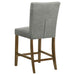 Pair of grey upholstered CoasterEveryday counter height dining chairs with wooden legs, shown in a modern kitchen setting.