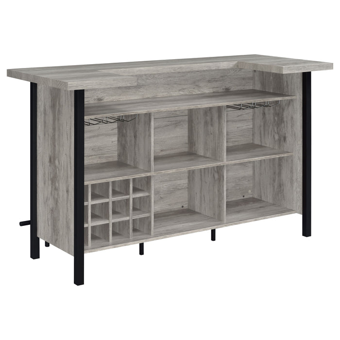 Gray driftwood CoasterEssence Bellemore freestanding home bar wine cabinet with storage for bottles and glassware.