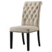 Set of two beige CoasterEveryday Alana fabric upholstered dining side chairs with wooden legs and cushioned seats.