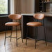 Set of two brown and black 29-inch faux leather and steel low back bar height chairs by HomeRoots, featuring modern design.