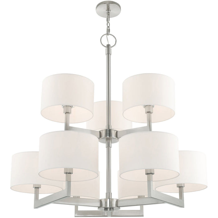 HomeRoots 43-inch nine-light metal chandelier with dimmable off-white shades and nickel finish, hanging with visible light fixtures and chain.