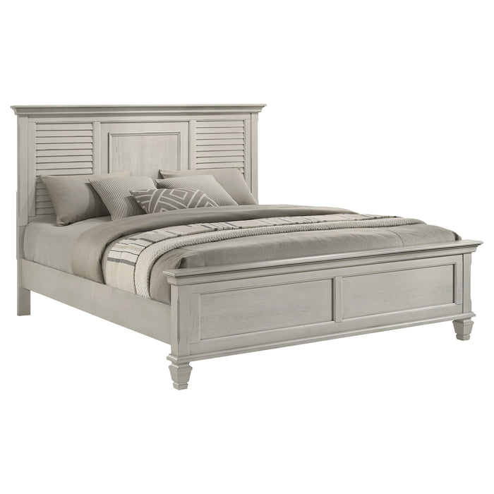 Distressed white Franco Wood Eastern King Panel Bed by CoasterEssence showing a wooden bed frame with carved details and a tall headboard.