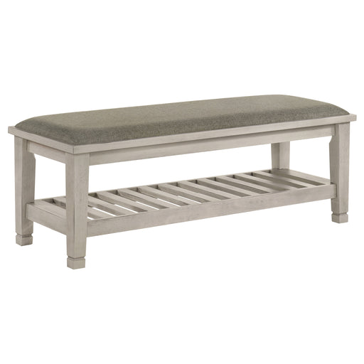 Distressed white upholstered fabric bench with shelf, CoasterEssence furniture piece, showing plush seating and sturdy storage shelf.