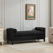 Black boucle upholstered bench with wood legs and two bolster pillows, serving as a stylish daybed or ottoman by Giga.