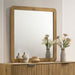 CoasterEveryday Bennett mid-century square dresser mirror with open-corner light oak frame, hanging on a bedroom wall.
