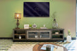 Brown distressed wooden TV stand with enclosed cabinet storage, part of HomeRoots' collection, featuring a rustic design for living rooms.