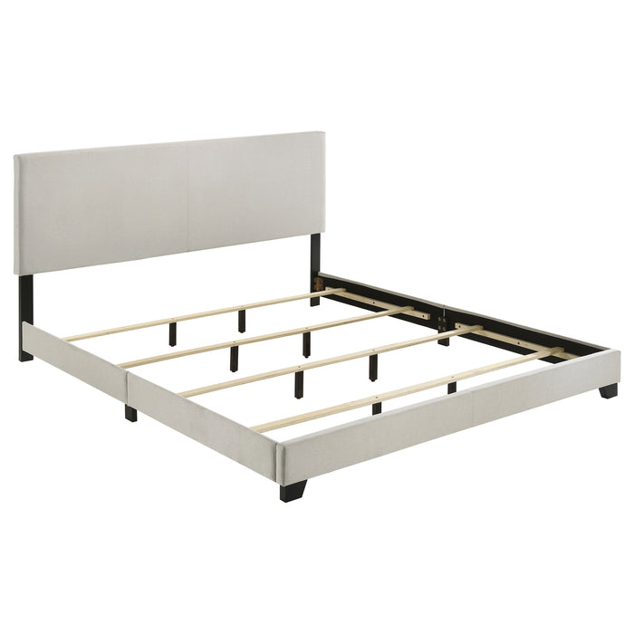 Cream fabric upholstered California King panel bed with a sleek, modern design and sturdy wooden frame.