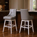 Set of two HomeRoots 29-inch gray and white faux leather and solid wood swivel bar chairs with high backs and modern design.