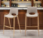 Set of two beige faux leather and steel low back bar height chairs with gold accents, ideal for home bar or counter seating.