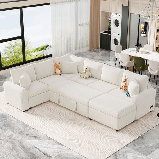 Giga sectional sofa sleeper with storage ottoman, three pillows, and charging devices in a modern living room setting.