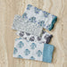 Set of four TOV Furniture Crissy cotton canvas printed napkins in blue cornflower design, showcasing vibrant floral pattern.
