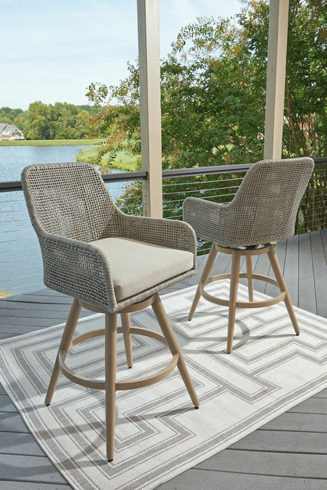 Set of two beige and gray Seton Creek barstools with cushioned seats by Signature Design, showcasing stylish, comfortable seating.