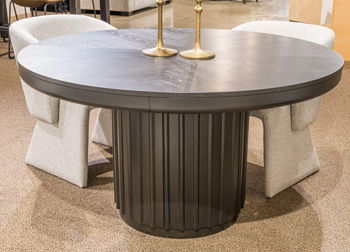 Black Haldenwick round dining room table by Signature Design Ashley, showcasing a sleek, modern dining surface with sturdy legs.