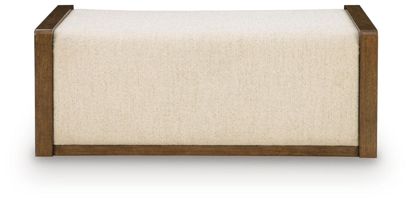 Brown upholstered storage ottoman from Signature Design by Ashley®, featuring a cushioned top and spacious interior for versatile use.