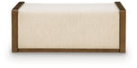Brown upholstered storage ottoman from Signature Design by Ashley®, featuring a cushioned top and spacious interior for versatile use.