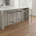 Set of four brown and silver stainless steel backless bar height stools from HomeRoots, showcasing sleek modern design.