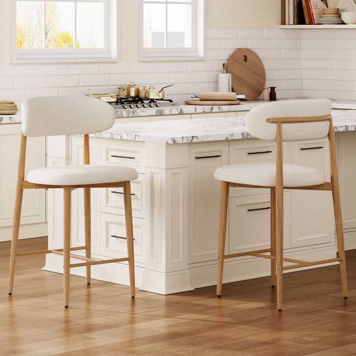 Set of two beige upholstered Giga counter height bar stools with wooden legs, ideal for kitchen islands.