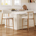 Set of two beige upholstered Giga counter height bar stools with wooden legs, ideal for kitchen islands.