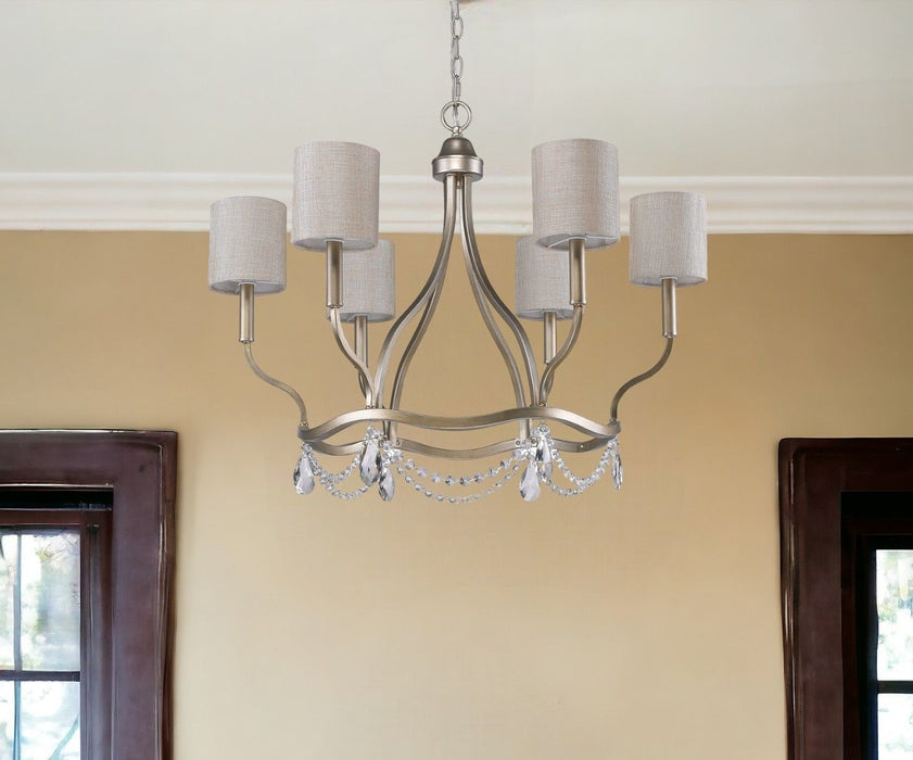 HomeRoots gold metal chandelier with six candle-style lights and white shades, dimmable for elegant lighting.