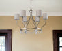 HomeRoots gold metal chandelier with six candle-style lights and white shades, dimmable for elegant lighting.