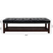 Giga upholstered bedroom end of bed bench with tufted cushion, nailhead trim, shelf, and shoe rack in a cozy living room setting