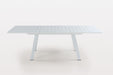 Contemporary Malibu outdoor extendable dining table by Chintaly in matte white aluminum with butterfly leaf for outdoor dining.