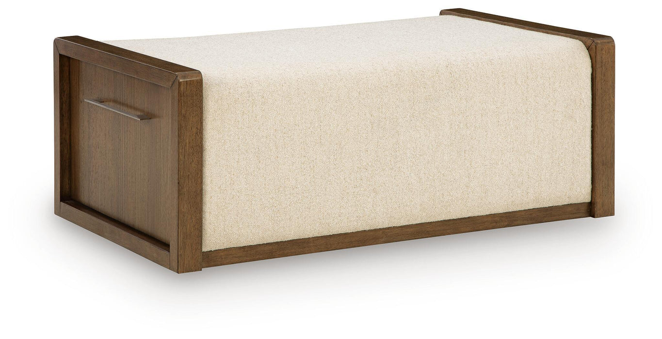 Brown upholstered storage ottoman by Signature Design Ashley, featuring a cushioned top and hidden storage space.