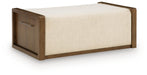 Brown upholstered storage ottoman by Signature Design Ashley, featuring a cushioned top and hidden storage space.