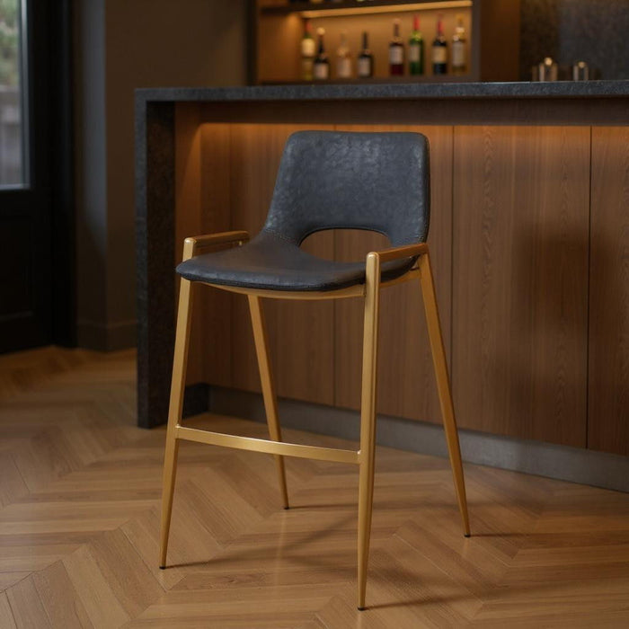 Set of two black faux leather and steel low back bar height chairs with gold accents, perfect for bar or counter seating.