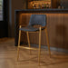 Set of two black faux leather and steel low back bar height chairs with gold accents, perfect for bar or counter seating.