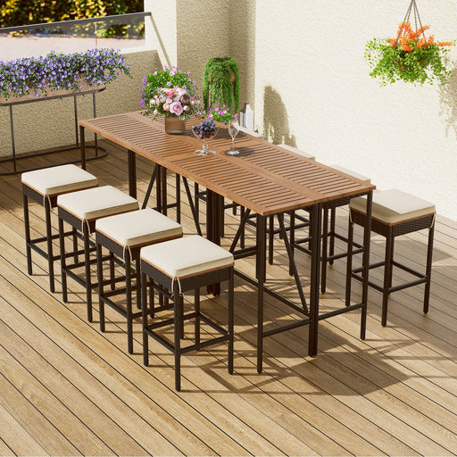 Giga outdoor acacia wood bar height table with eight cushioned stools, ideal for patio or garden dining and entertaining.