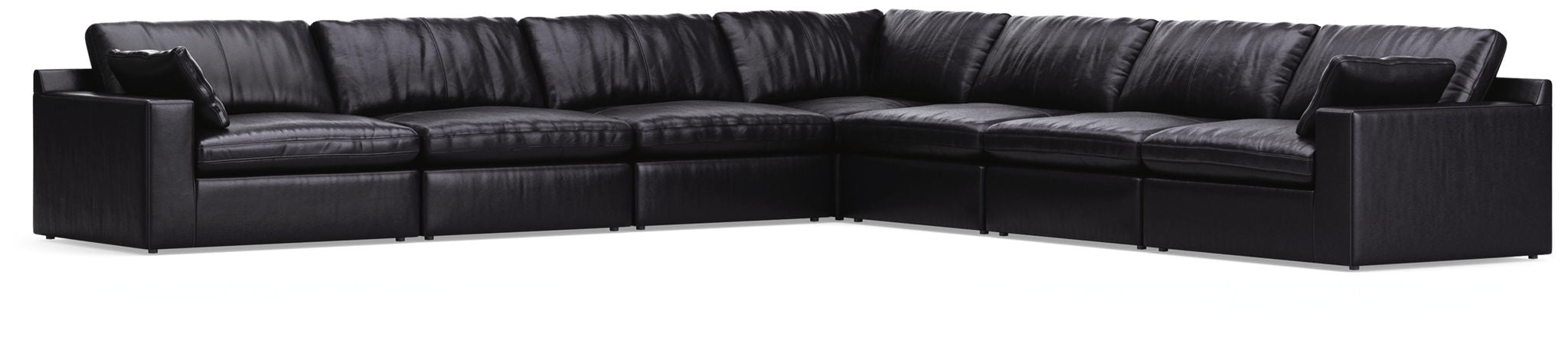 Signature Design by Ashley Emilia stationary sectional with plush cushions and modern fabric upholstery in a stylish living room setting.