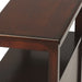 Dark brown manufactured wood end table with two drawers and a shelf, ideal for living room or bedroom decor.