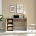 Giga home office desk in light brown with one cabinet, three shelves, faux barn door, metal euro hinges, and modesty panel.