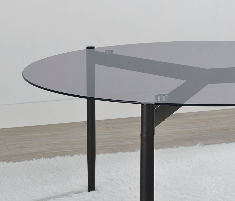Round smoked glass top coffee table in grey with sleek metal legs, modern furniture piece by CoasterEveryday.