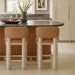 Set of two Meridian Furniture Paloma vegan leather counter stools with tan upholstered seats and wooden legs.