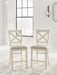Set of two Robbinsdale upholstered barstools by Signature Design Ashley in antique white fabric with wooden legs.