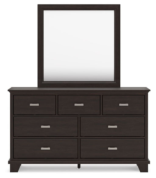 Dark brown Covetown dresser and mirror set by Signature Design Ashley, showcasing a stylish storage and dressing area.