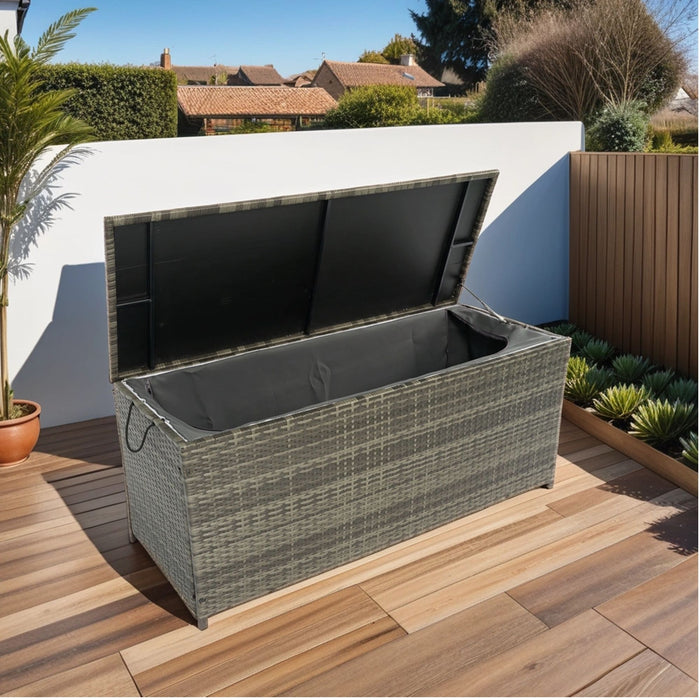 Giga outdoor wicker storage box with lid, patio deck cabinet for cushions, toys, pillows, and towels in a garden setting.