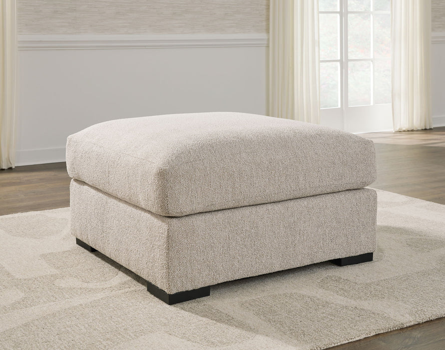 Benchcraft Ballyton oversized accent ottoman in sand fabric, plush cushioned top with wooden legs, versatile and stylish for living spaces.