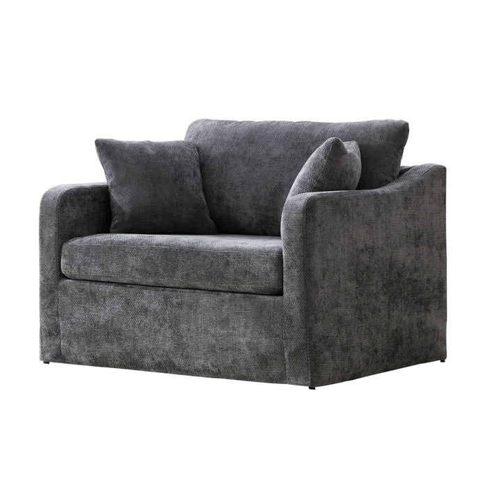 Giga farmhouse armchair with two bolster pillows, rustic wooden legs, and cozy fabric upholstery in a warm, inviting setting.