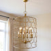 Gold metal chandelier with twelve candle-style lights and shades, featuring a modern chandelier design by HomeRoots.