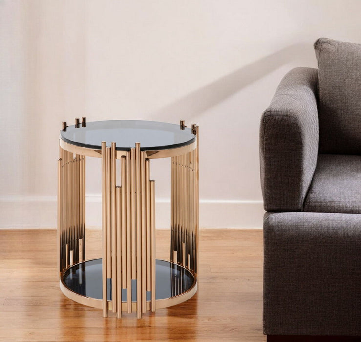HomeRoots round end table with glass top, stainless steel frame, rose gold finish, and black shelf for modern living spaces.