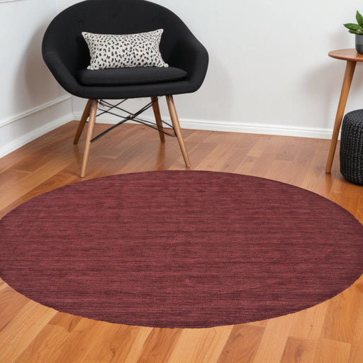 Red 10-foot round wool hand-woven area rug by HomeRoots, showcasing intricate woven texture and vibrant color.