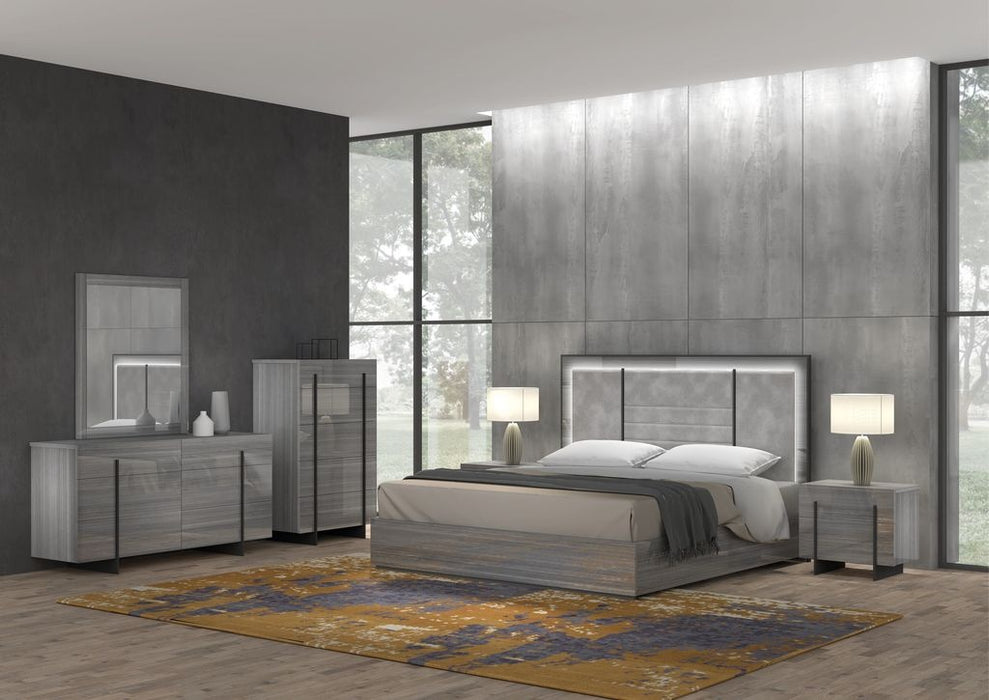 J & M Furniture Blade Premium Moon Grey Mirror hanging on wall with sleek, modern design and reflective surface.