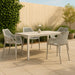 Set of two Meridian Furniture Mykonos outdoor dining chairs with woven seats and metal frames, perfect for patio or garden dining.